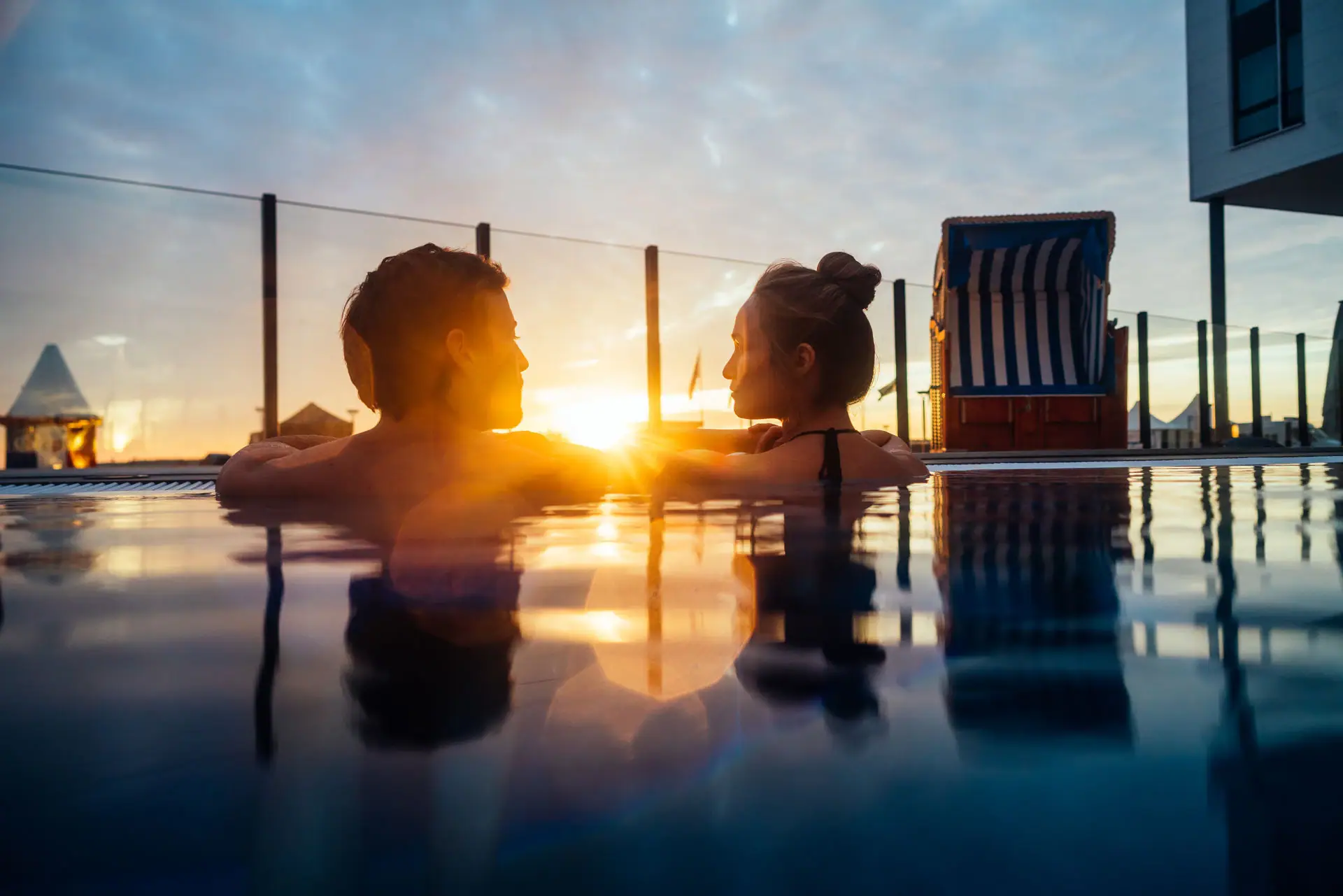 Outdoor swimming pool A man and a woman in the outdoor pool at sunset.